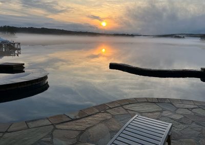 Infinity Edge Pool Looks Like Part Of The Lake. Photo At Sunset